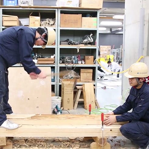 釿で丸太を加工する